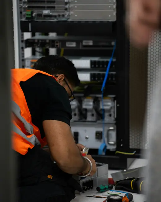 Técnico trabajando en un rack de red con sus herramientas
